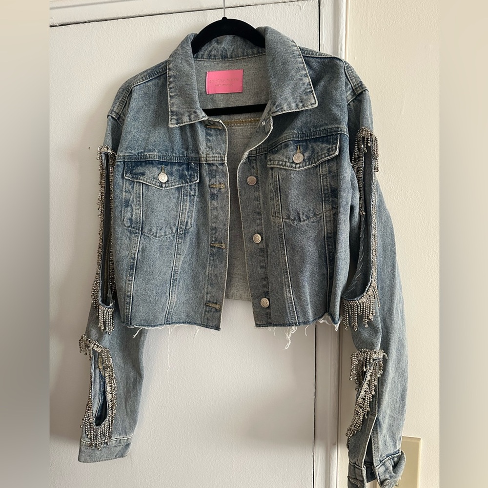 Cropped denim jacket with arm cutouts.